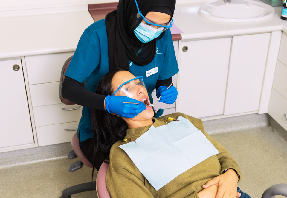 dentist wearing hijab removing patient's wisdom tooth